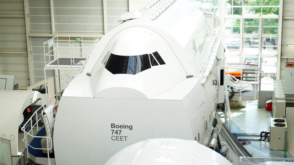 A Cabin Emergency Evacuation Trainer (CEET) for a Boeing 747 aircraft is standing in a training hall