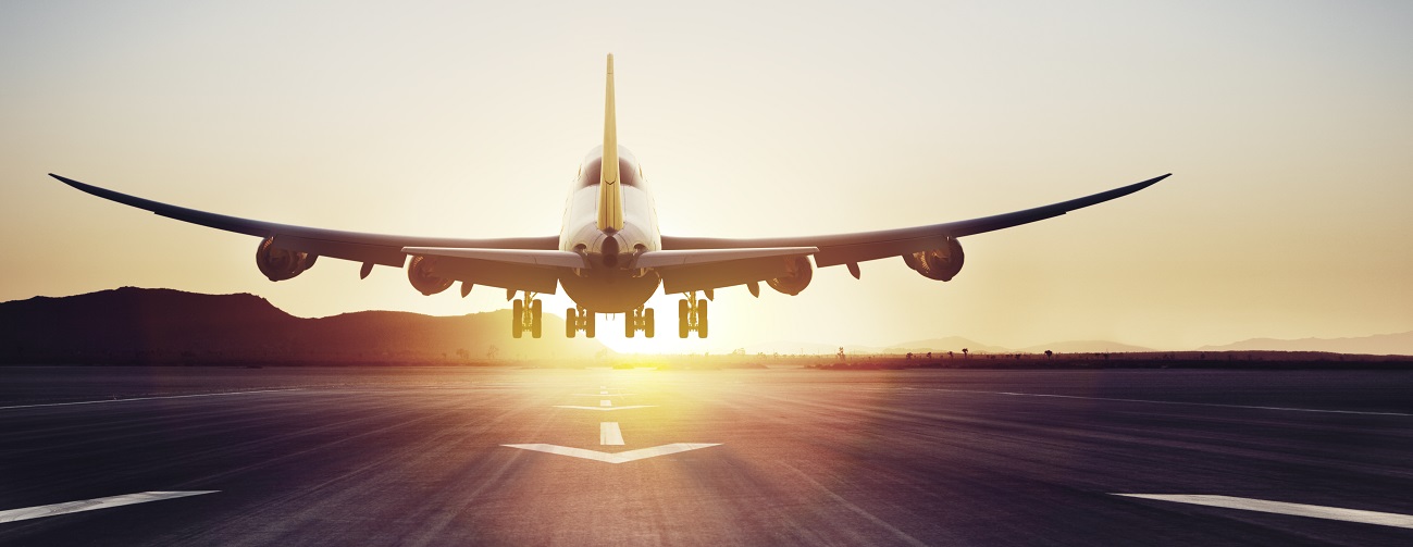 An airplane is landing at sunset.