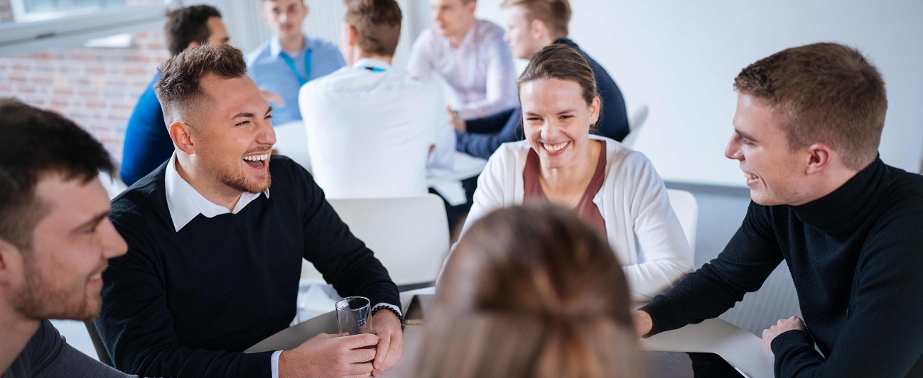 Several people are sitting at a table, talking and laughing.