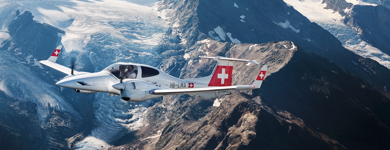 Several flight students are walking toward a Diamond aircraft.