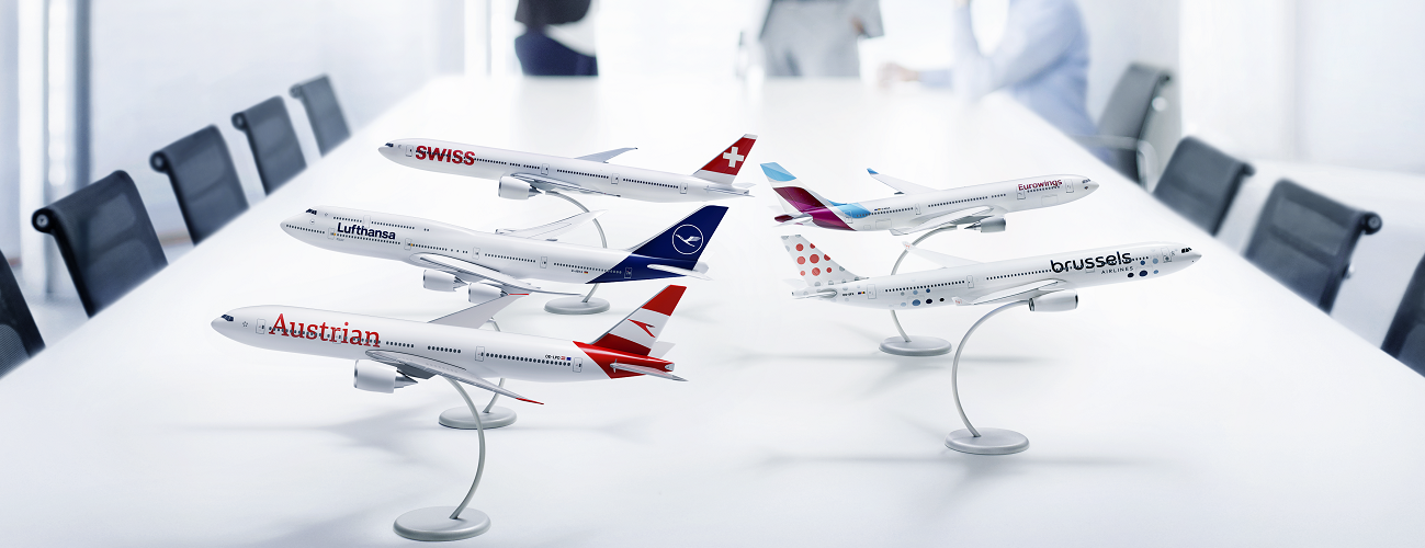 Auf einem langen Besprechungstisch stehen Flugzeugmodelle der Lufthansa Group Airlines