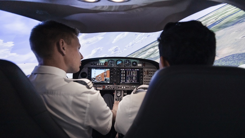 Two trainee pilots train in a DA42 simulator