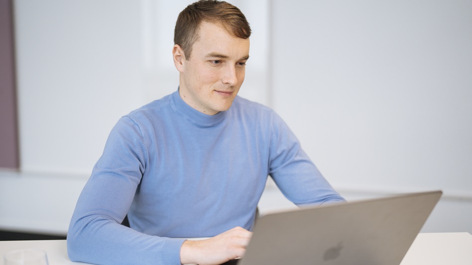 Eine Person unterhält sich lächelnd mit einer anderen Person, von der man nur den Hinterkopf sieht.