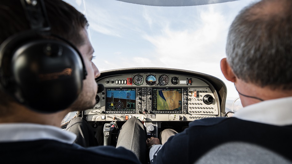 Eine Flugschüler:in und eine Trainer:in sitzen im Cockpit einer DA42 und fliegen.