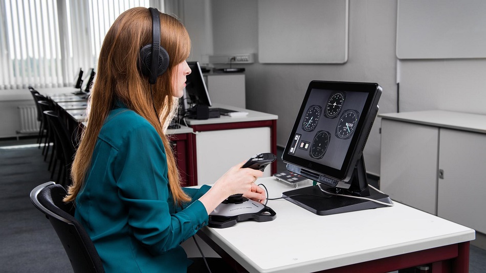  A person sits with a joystick in front of a PC running a flight simulator.