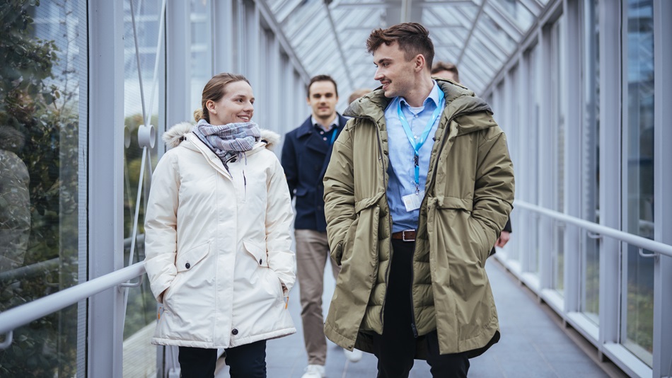 Several cheerful students are walking across the campus.