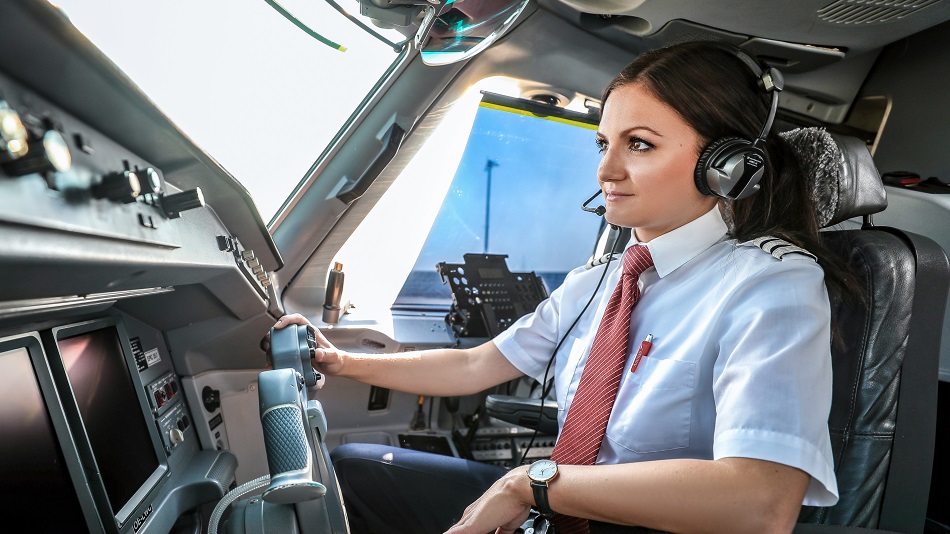 A first officer stands smiling in front of an Airbus A350.