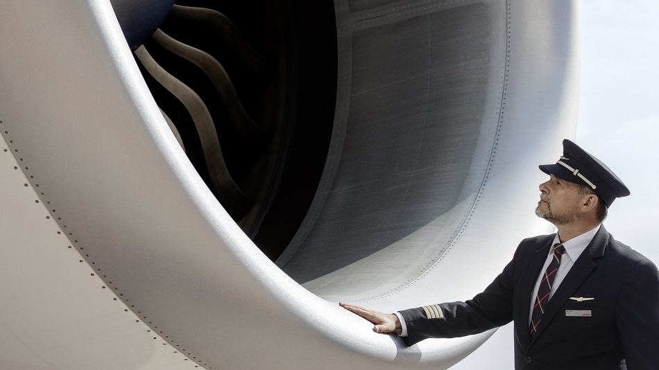  A captain stands in front of an aircraft turbine.