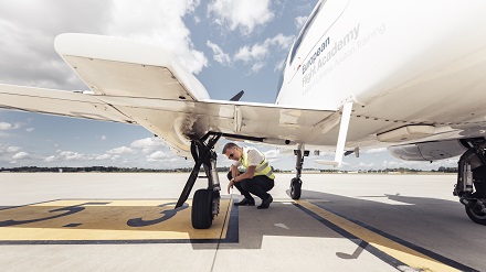 A student pilot from the Lufthansa Group's flight school takes a close look at the tire of a training aircraft.